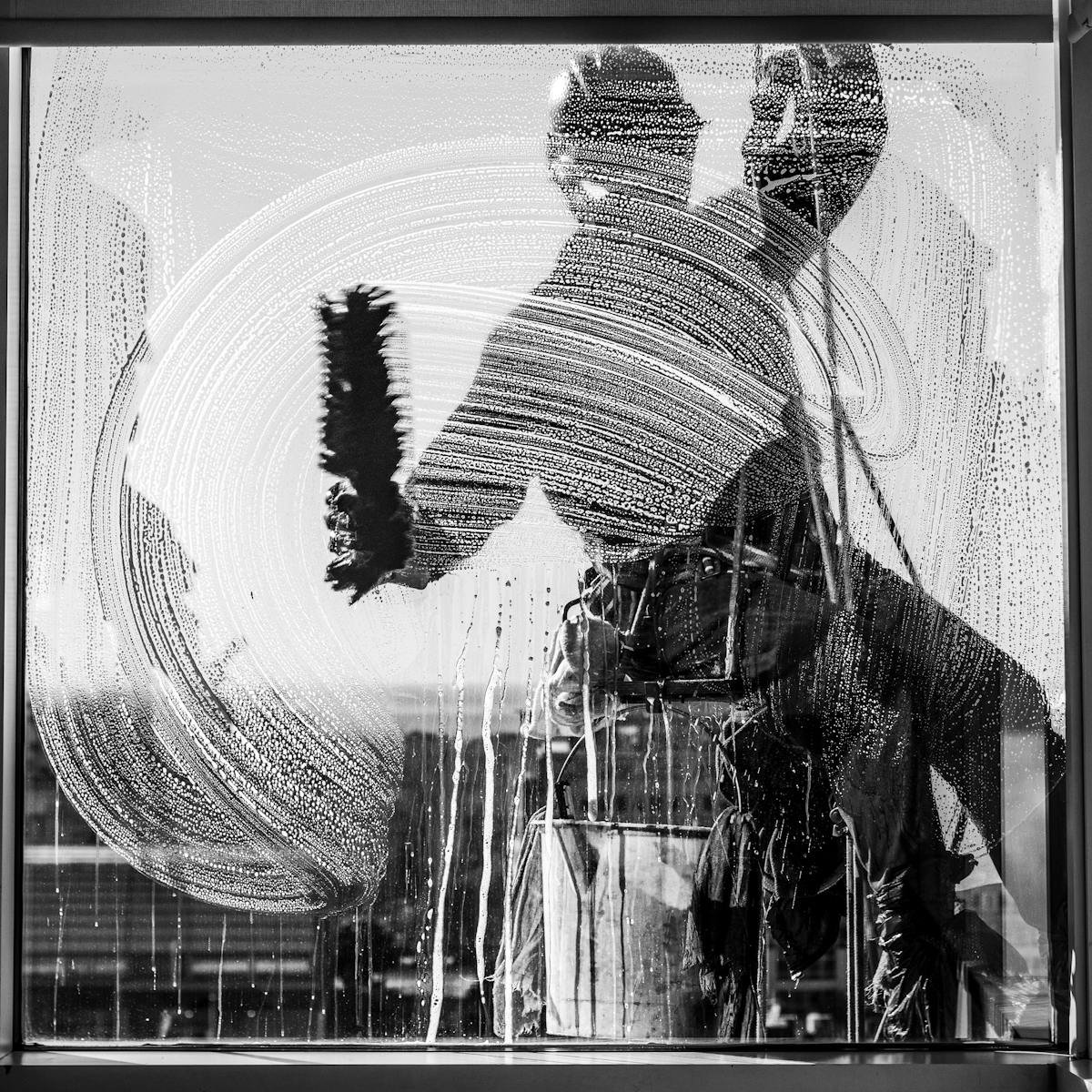 servicios Silhouette of a window cleaner working on a skyscraper in Buenos Aires.