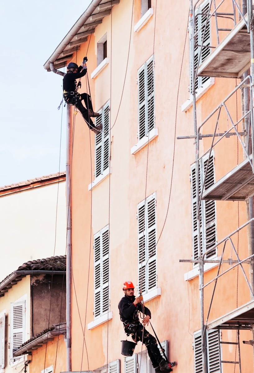 contacto Skilled technicians using rope access for façade repairs on a multi-story building.